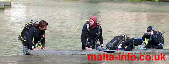 4 divers kitting up against a jetty